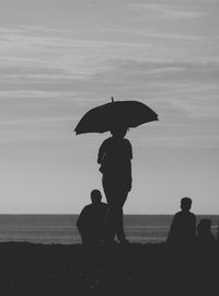 Silhouette people on beach during sunset