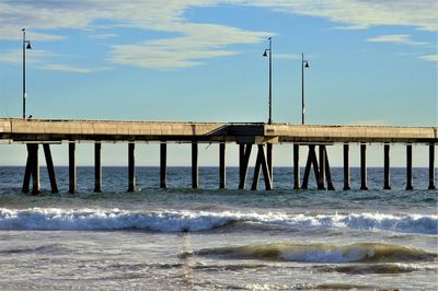 Wooden pier over sea against sky