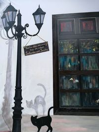 Close-up of electric lamp hanging against sky