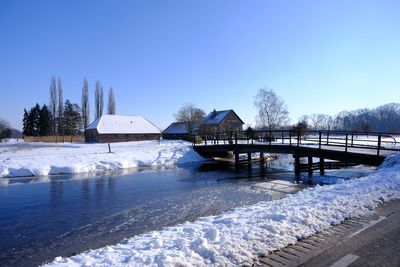 Scenic view of frozen lake against clear blue sky