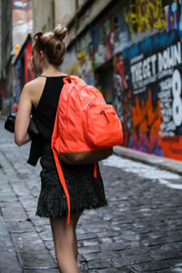 Rear view of woman standing on footpath