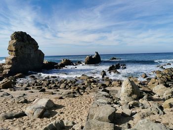 Rocks on beach against sky