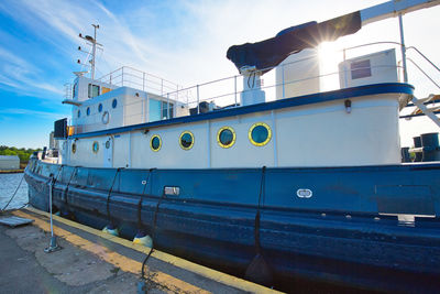 Ship moored at harbor against sky