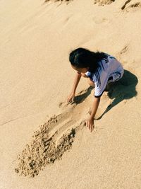 High angle view of girl playing at sandy beach
