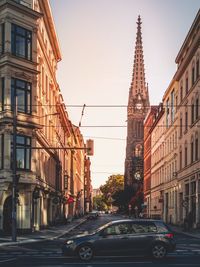 Cars on road amidst buildings against clear sky