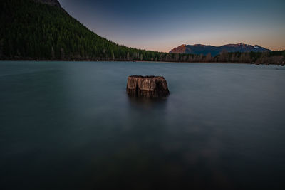 Scenic view of lake by mountain against sky