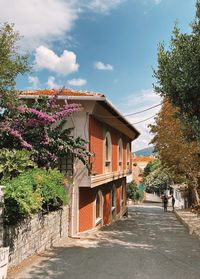 Houses by road amidst buildings against sky