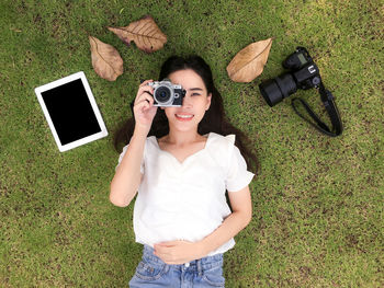 Portrait of smiling young woman lying down on grass