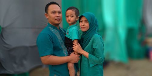 Portrait of smiling family standing in room