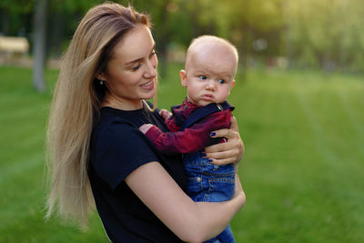 Mother carrying cute son in park