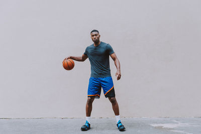 Full length portrait of young man playing with ball