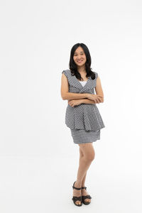 Portrait of smiling young woman against white background