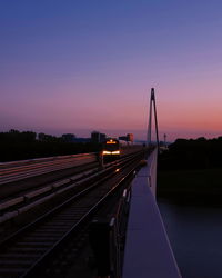 Railroad tracks against sky at sunset