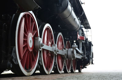 Steam train on footpath against clear sky