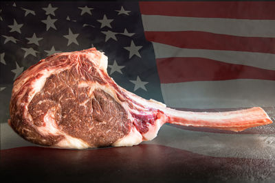 4th of july, independence day raw, dry aged wagyu tomahawk steak with american flag 