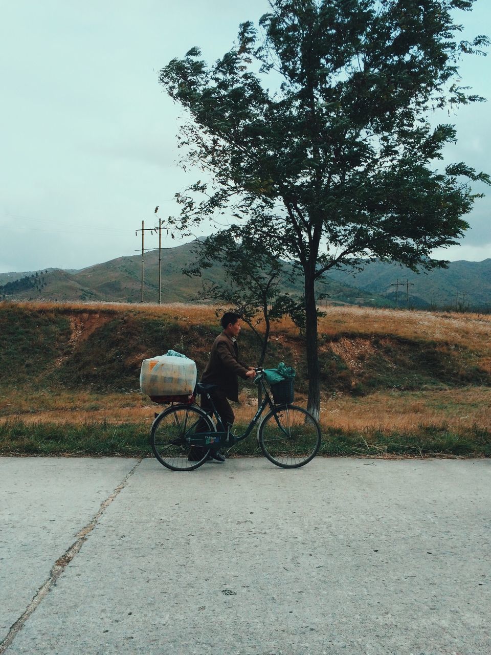 bicycle, sky, transportation, tree, land vehicle, landscape, tranquility, field, tranquil scene, mode of transport, nature, road, sunlight, scenics, day, outdoors, dirt road, parked, stationary, no people