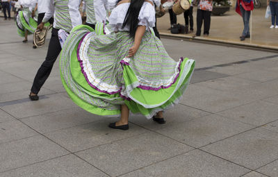 Low section of people dancing on footpath