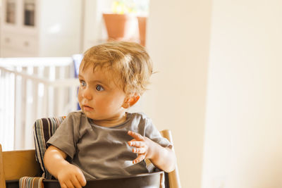 Close-up of cute boy sitting on chair