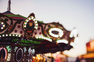 Low angle view of illuminated carousel against sky