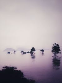 Scenic view of lake against sky during foggy weather