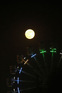 Low angle view of illuminated lights against sky at night