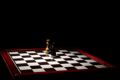 Low angle view of chess against black background