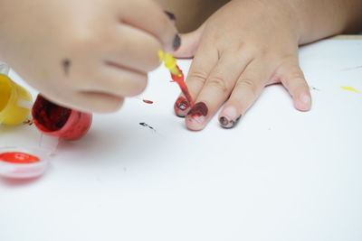 Close-up of hand holding paper painting on table