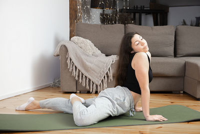 Slim fitness young girl practices relaxation yoga indoor at home. sport, healthy lifestyle.