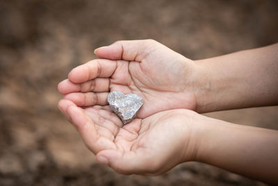 Cropped hands of woman holding stone