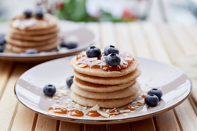 Traditional pancakes with fresh blueberries and agave syrup on a plate. breakfast on the terrace 