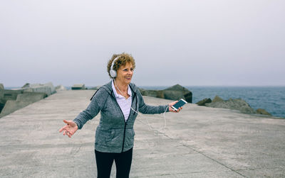 Portrait of woman standing in sea against sky
