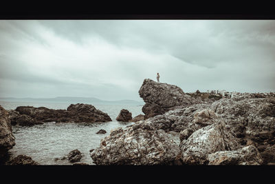 Panoramic view of rocks on sea shore against sky