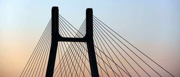 Low angle view of suspension bridge against sky