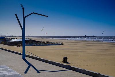 Scenic view of beach against clear blue sky