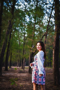 Full length of woman standing in forest