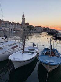 Boats moored at harbor during sunset