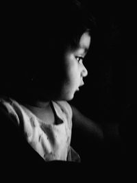 Close-up of boy in black background