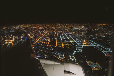 Aerial view of illuminated city against sky at night
