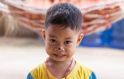 Close-up portrait of cute boy with nose injury standing outdoors