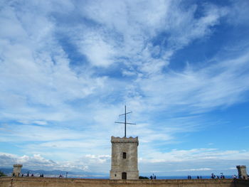 Tower of building against cloudy sky