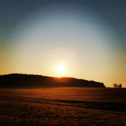 Scenic view of silhouette land against clear sky during sunset