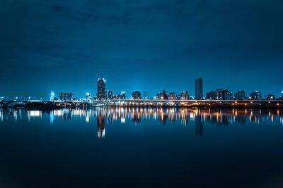 Reflection of illuminated buildings in city at dusk