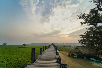 View of empty footpath leading towards landscape