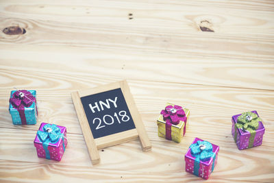 High angle view of message on blackboard by gifts over table