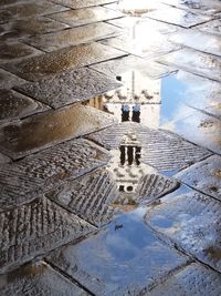 High angle view of puddle on street amidst buildings