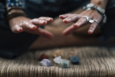 Low section of woman gesturing on stones