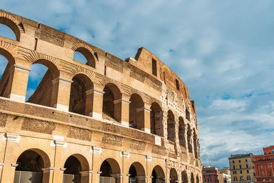 Low angle view of old amphitheater against cloudy sky