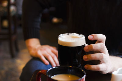 Close-up of hand holding beer glass