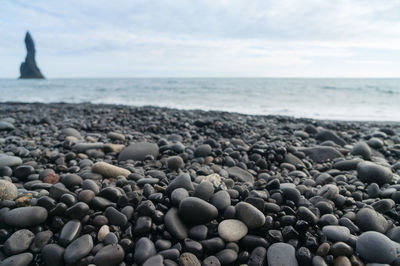 Surface level of pebble beach against sky