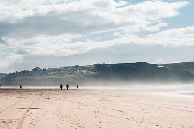 People walking on land against sky